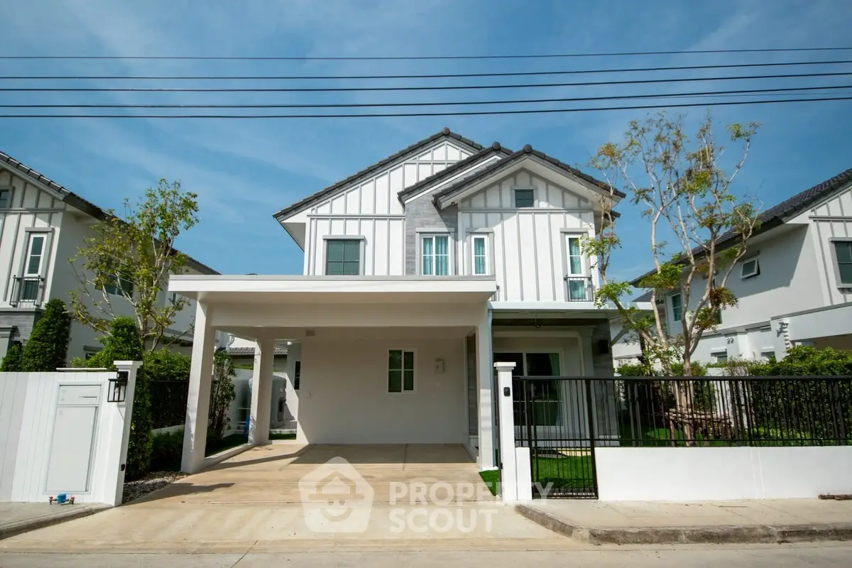 Modern two-story house with carport and landscaped front yard in a suburban neighborhood.