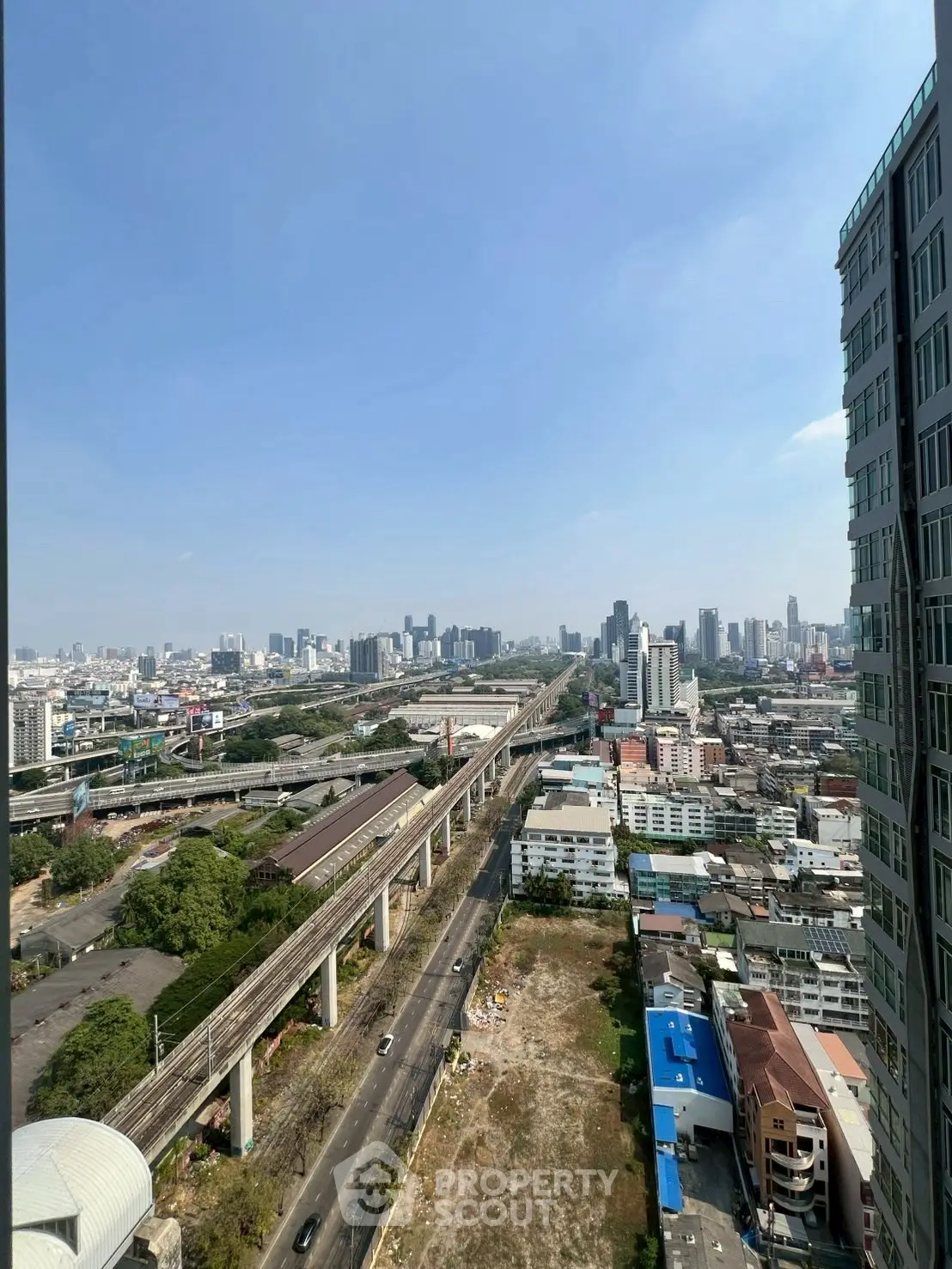 Stunning cityscape view from high-rise building overlooking urban skyline and railway.