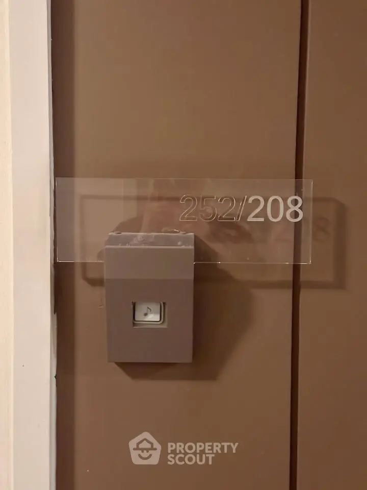 Modern apartment door with sleek room number signage and secure access system.