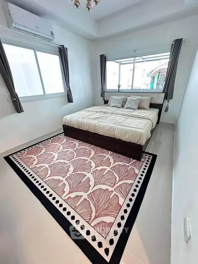 Spacious bedroom with elegant decor and large windows for natural light.