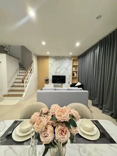 Elegant living room with modern decor, marble accent wall, and cozy seating area, perfect for relaxation.