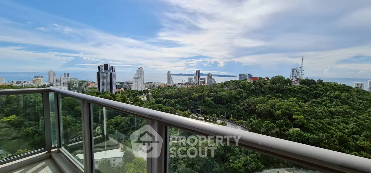Stunning cityscape view from a high-rise balcony overlooking lush greenery and skyline.