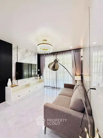 Modern living room with sleek design, featuring a wall-mounted TV, elegant lighting, and stylish decor.