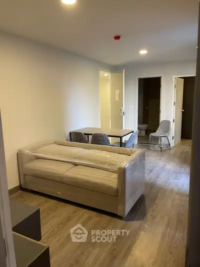 Modern living room with sleek furniture and wooden flooring in a cozy apartment.