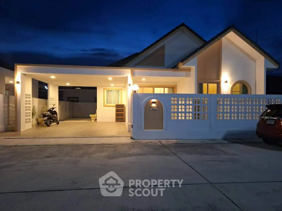 Charming modern house with spacious driveway and elegant exterior lighting at dusk.