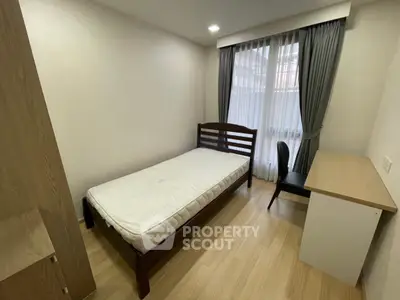 Cozy minimalist bedroom with single bed and study desk, perfect for students or professionals.