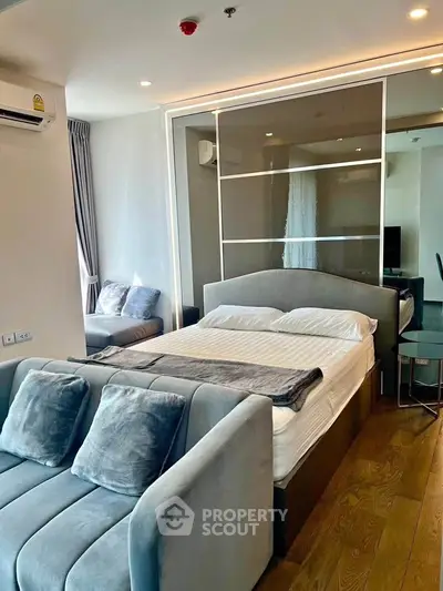 Modern bedroom with stylish decor and cozy seating area in a contemporary apartment.
