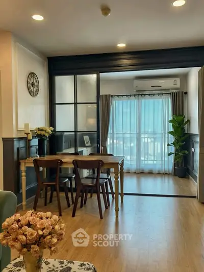 Charming dining area with glass partition and natural light in modern apartment.