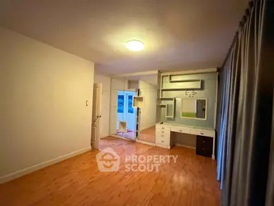 Spacious bedroom with wooden flooring and built-in mirrored wardrobe