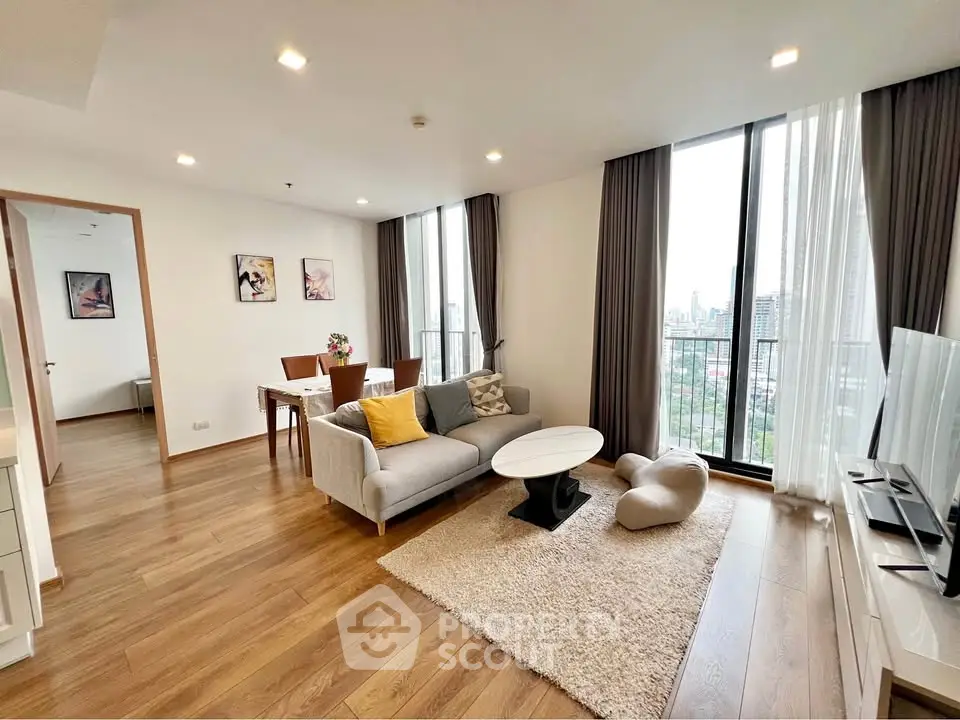 Spacious modern living room with city view, elegant decor, and natural light.