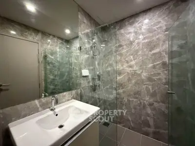 Modern bathroom with sleek glass shower and elegant marble walls