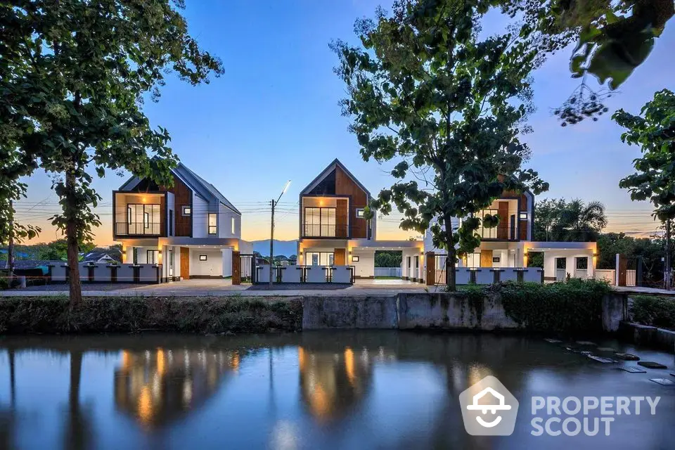 Stunning modern homes by the riverside with scenic sunset view and lush greenery.