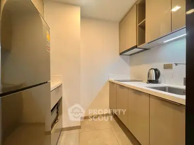 Modern kitchen with sleek cabinetry and stainless steel appliances in a contemporary apartment.