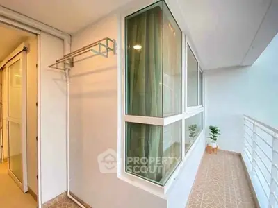 Charming balcony with modern railing and large windows, perfect for relaxation.
