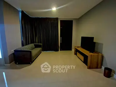 Modern living room with sleek sofa and large TV, perfect for relaxation and entertainment.