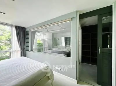 Modern bedroom with large window and view into stylish bathroom