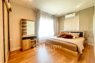 Spacious bedroom with wooden flooring and modern furnishings in a cozy apartment