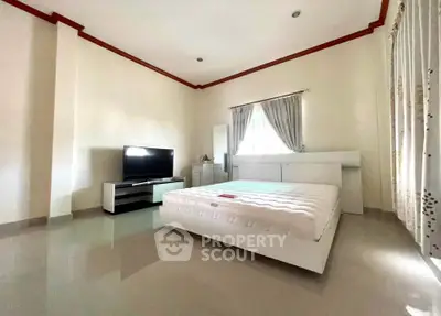 Spacious bedroom with modern furnishings and natural light