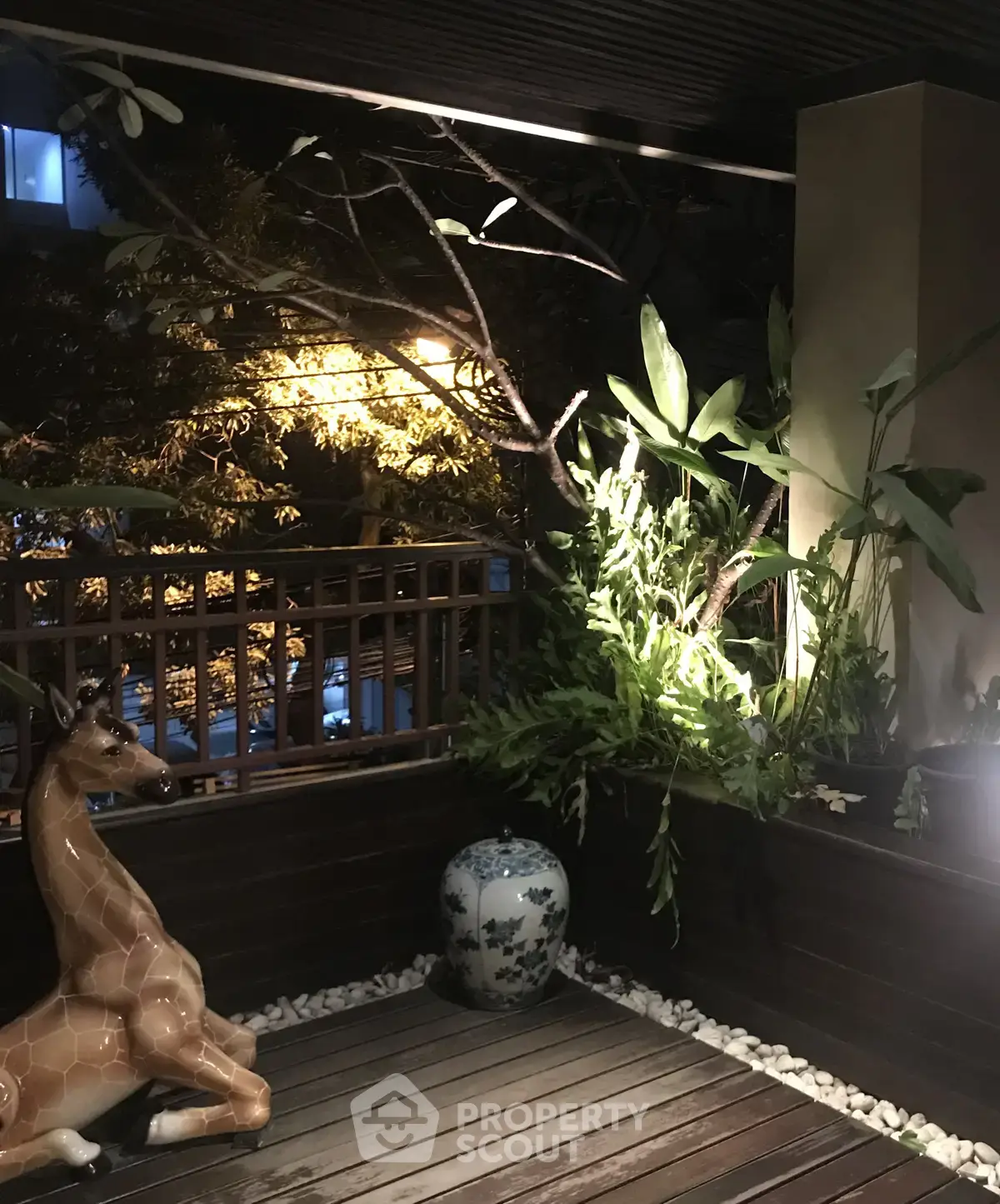 Charming balcony with wooden decking, lush plants, and decorative elements for a serene outdoor retreat.