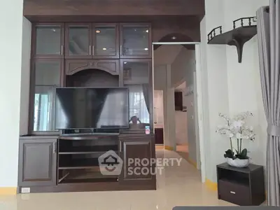 Spacious living room with elegant wooden entertainment center and modern decor