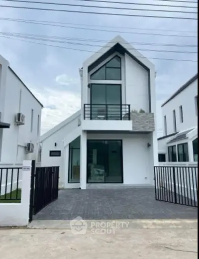 Modern two-story house with sleek design and large windows in a suburban neighborhood.