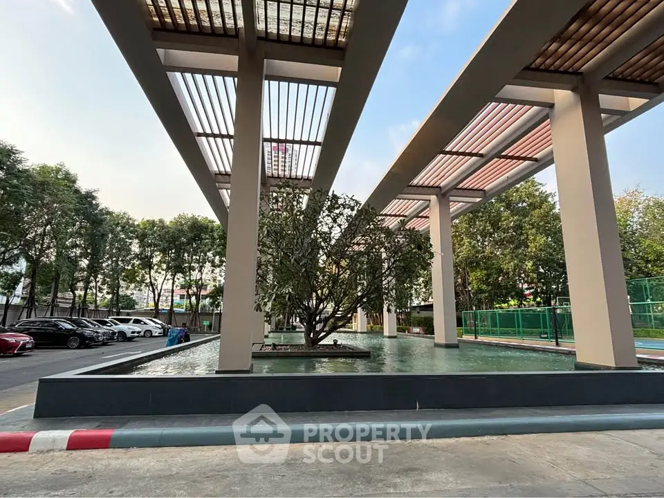 Modern outdoor area with water feature and trees in a residential complex