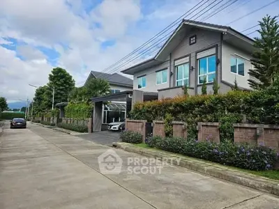 Modern two-story house with landscaped garden and driveway in suburban neighborhood.