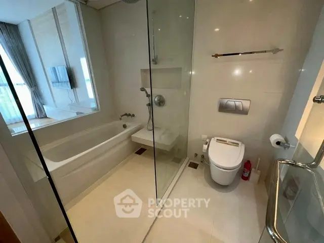 Luxurious modern bathroom with glass shower and bathtub in elegant apartment.