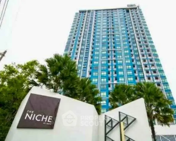 Modern high-rise building with lush greenery and sleek architectural design.