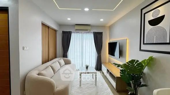 Modern living room with stylish decor, featuring a cozy sofa, wall-mounted TV, and elegant lighting.