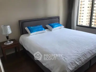 Spacious bedroom with large bed and city view window in modern apartment.