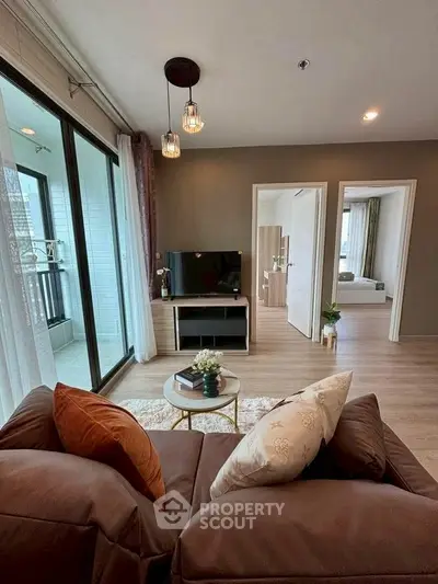 Modern living room with cozy sofa, TV, and balcony view in stylish apartment.
