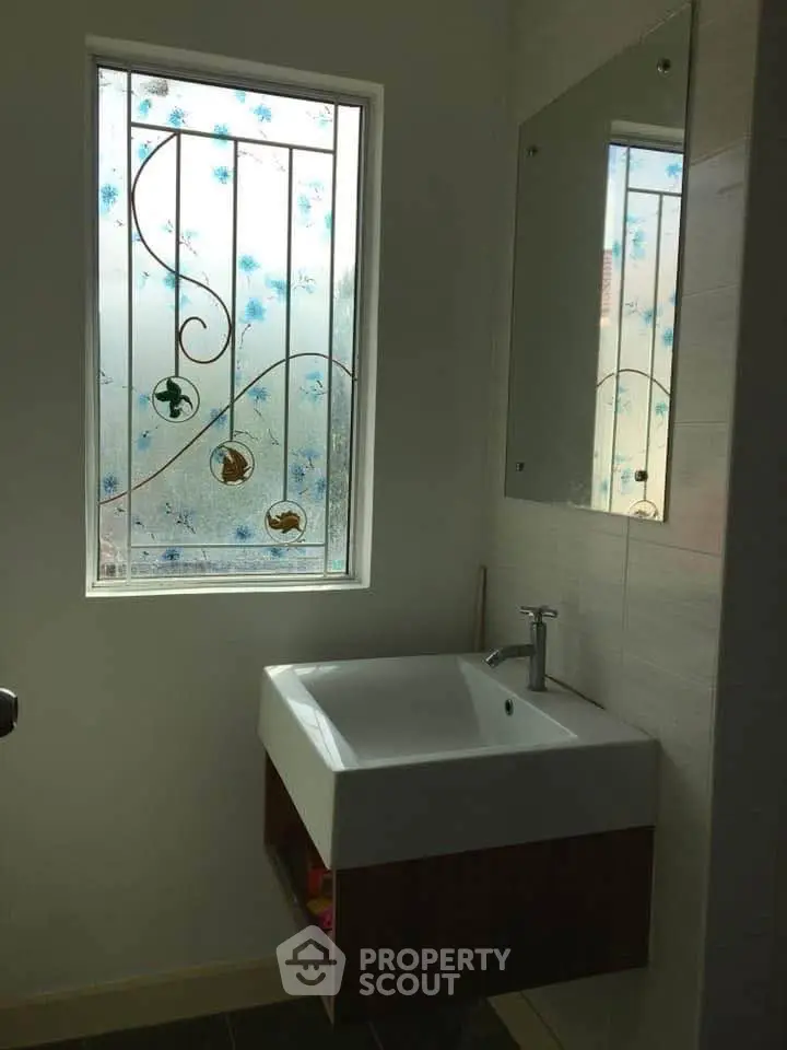 Elegant bathroom with decorative window and modern sink