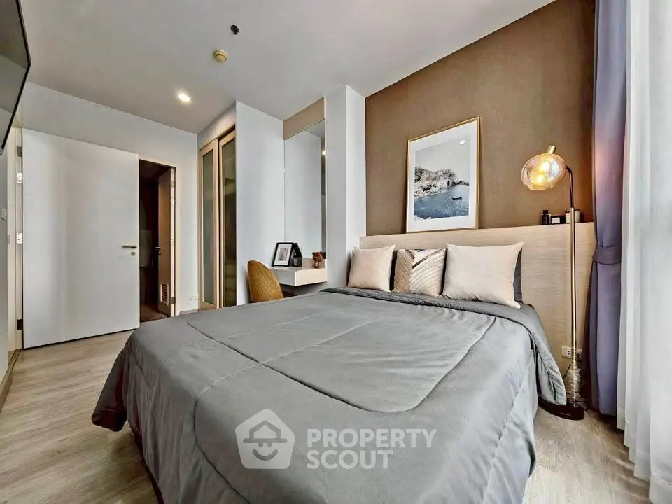 Modern bedroom with stylish decor and natural light, featuring a cozy bed and elegant furnishings.