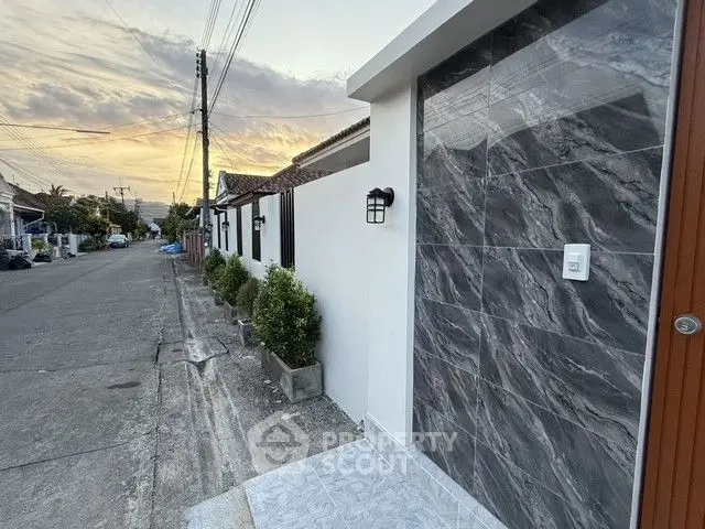Charming residential street with modern exterior wall and sunset view