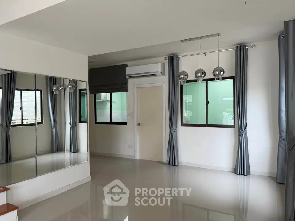 Spacious modern living room with large windows and elegant curtains