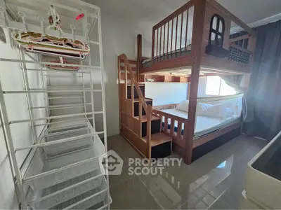 Spacious bedroom with modern bunk bed and ample storage space, perfect for family living.