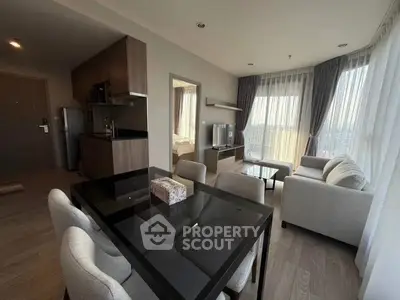 Modern open-plan living room with dining area and large windows offering city views.