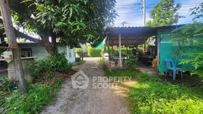 Charming rural property with lush greenery and outdoor seating area.