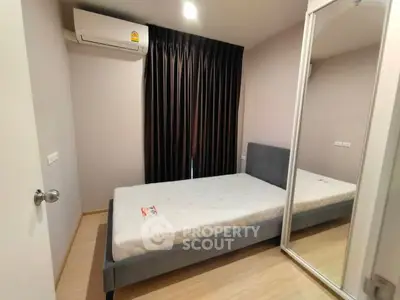 Cozy bedroom with mirrored closet and air conditioning in modern apartment