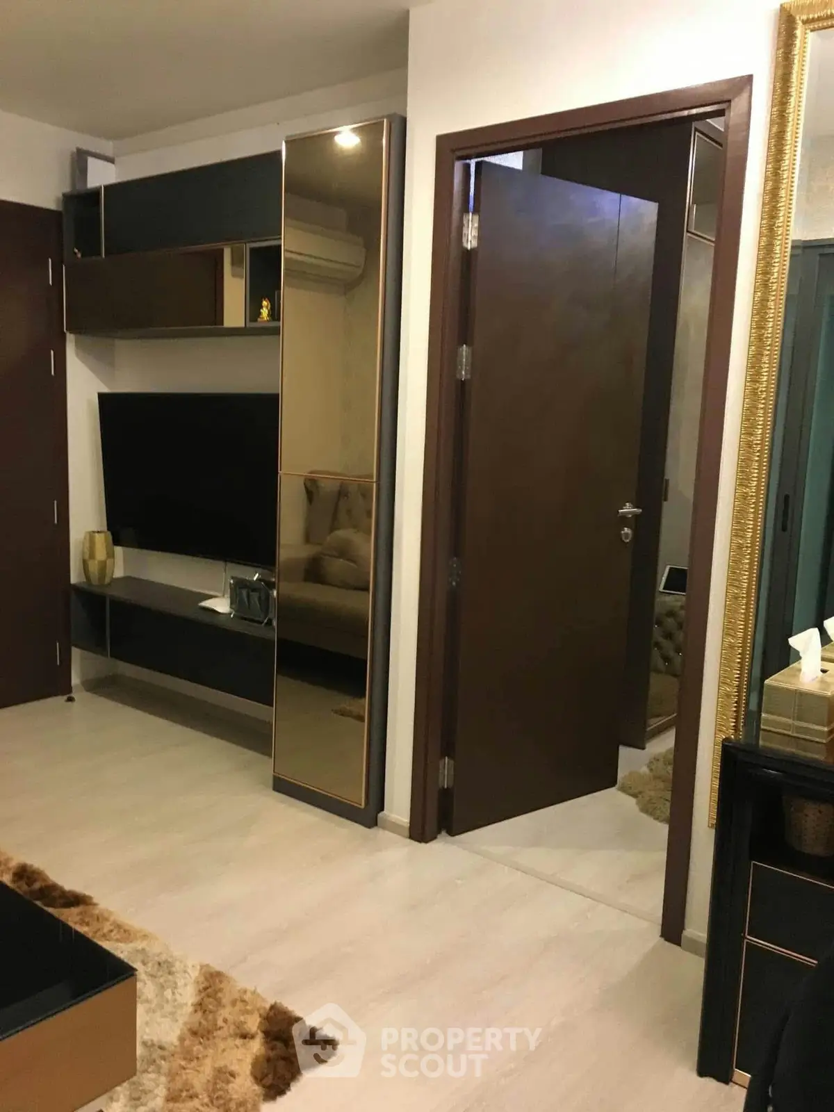Modern living room with sleek design and elegant decor, featuring a wall-mounted TV and stylish shelving.