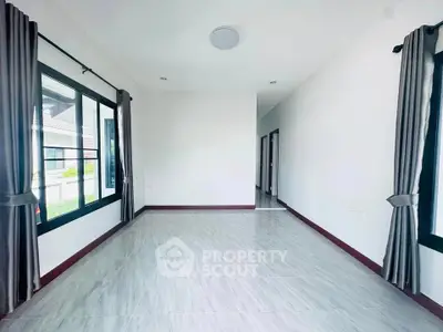 Spacious empty room with large windows and modern tile flooring, perfect for customization.
