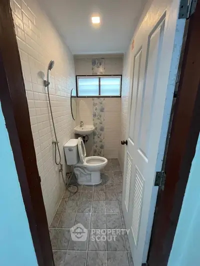 Compact bathroom with modern fixtures and tiled walls, ideal for small spaces.