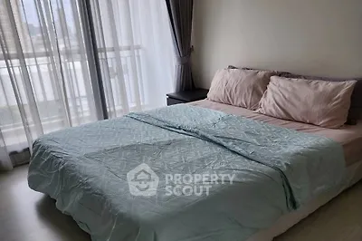 Cozy bedroom with large window and soft pastel bedding