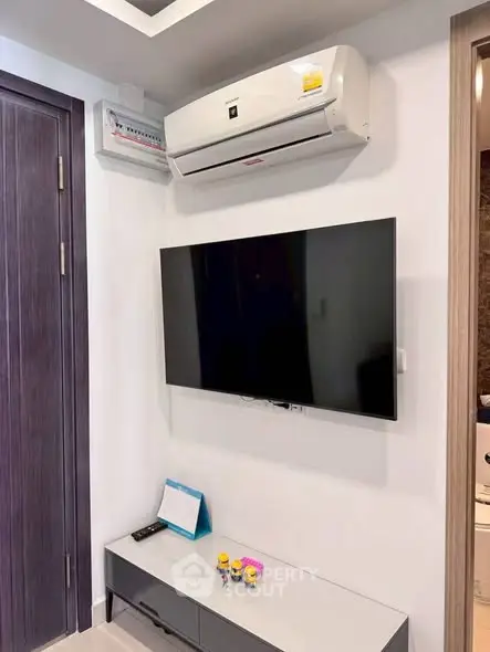Modern living room with wall-mounted TV and air conditioning unit