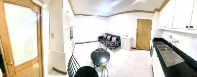 Spacious kitchen with dining area and cozy living space in modern apartment.