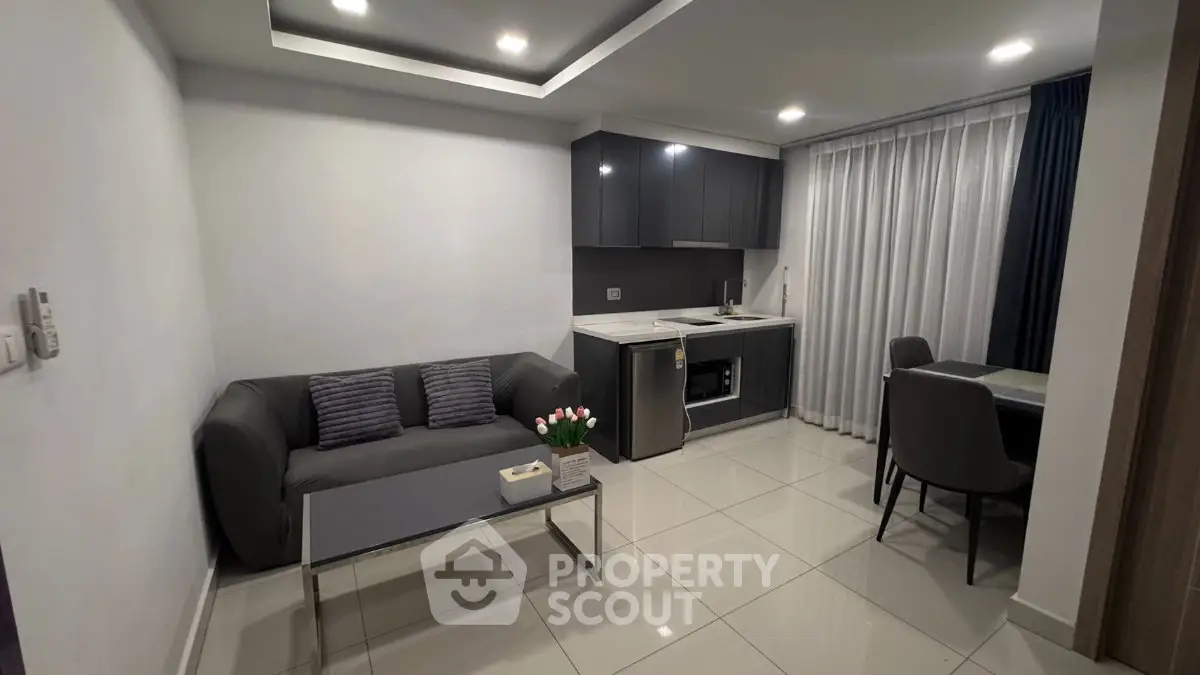 Modern living room with sleek kitchen and cozy seating area, perfect for urban living.