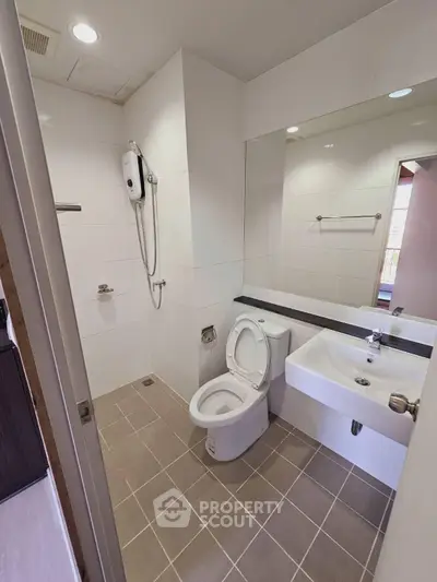 Modern bathroom with sleek fixtures and large mirror in a contemporary apartment.