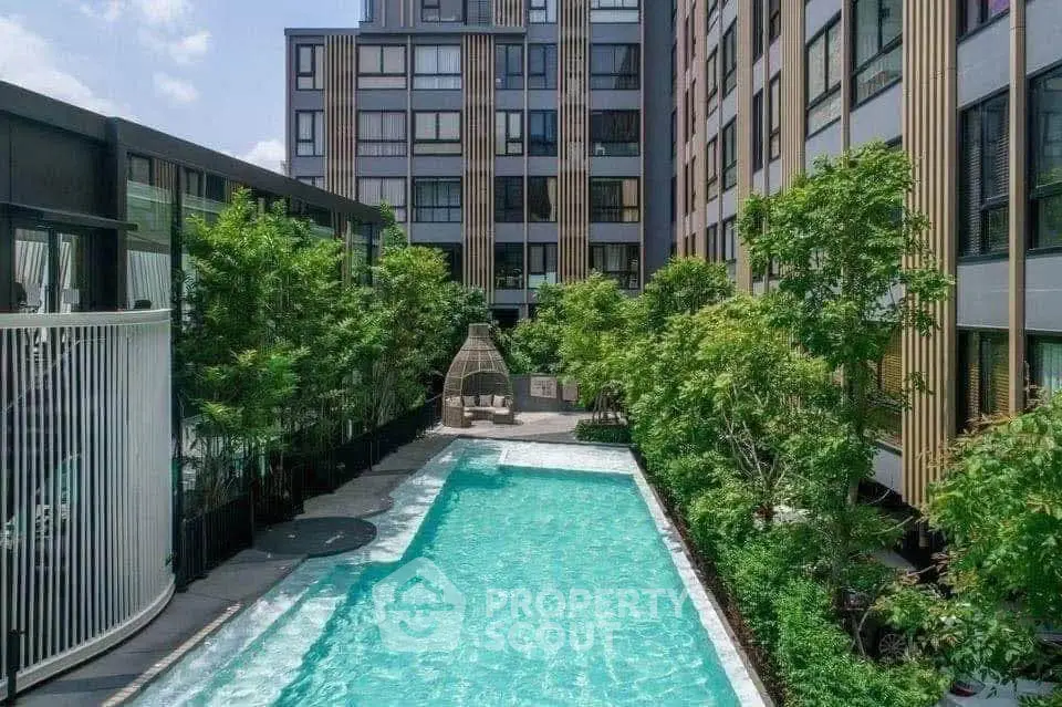 Luxurious apartment complex with modern pool and lush greenery