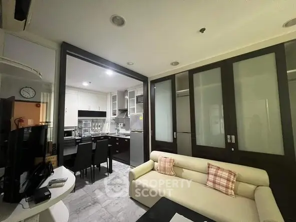 Modern open-layout kitchen and living room with sleek design and cozy seating area.